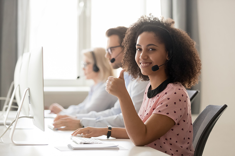 agent in wireless headset showing thumbs up gesture